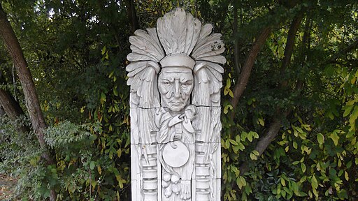 Photo of sculpture of Guardian of the Spirit in front of trees.